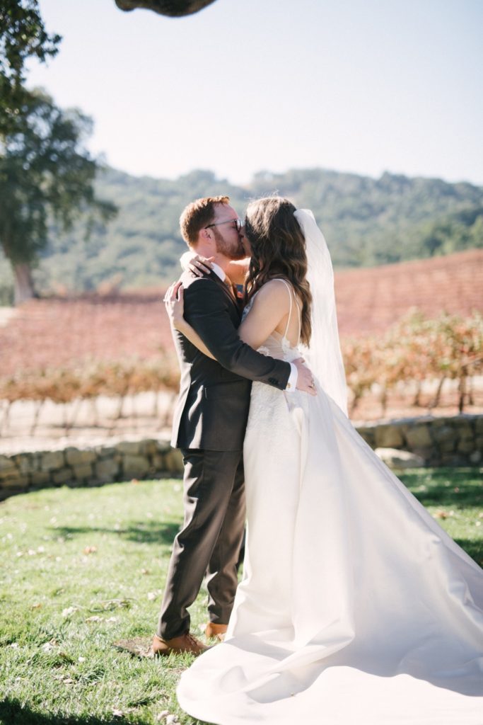 bride and groom exchange their first kiss as husband and wife