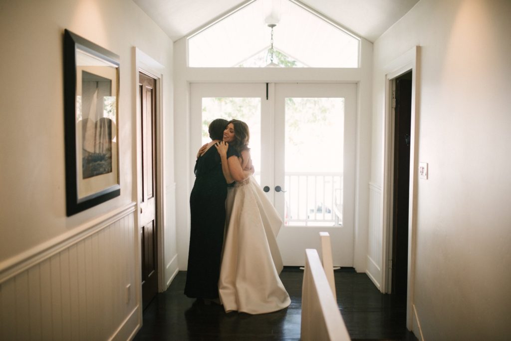 Mother of the bride helps her daughter get ready for her wedding