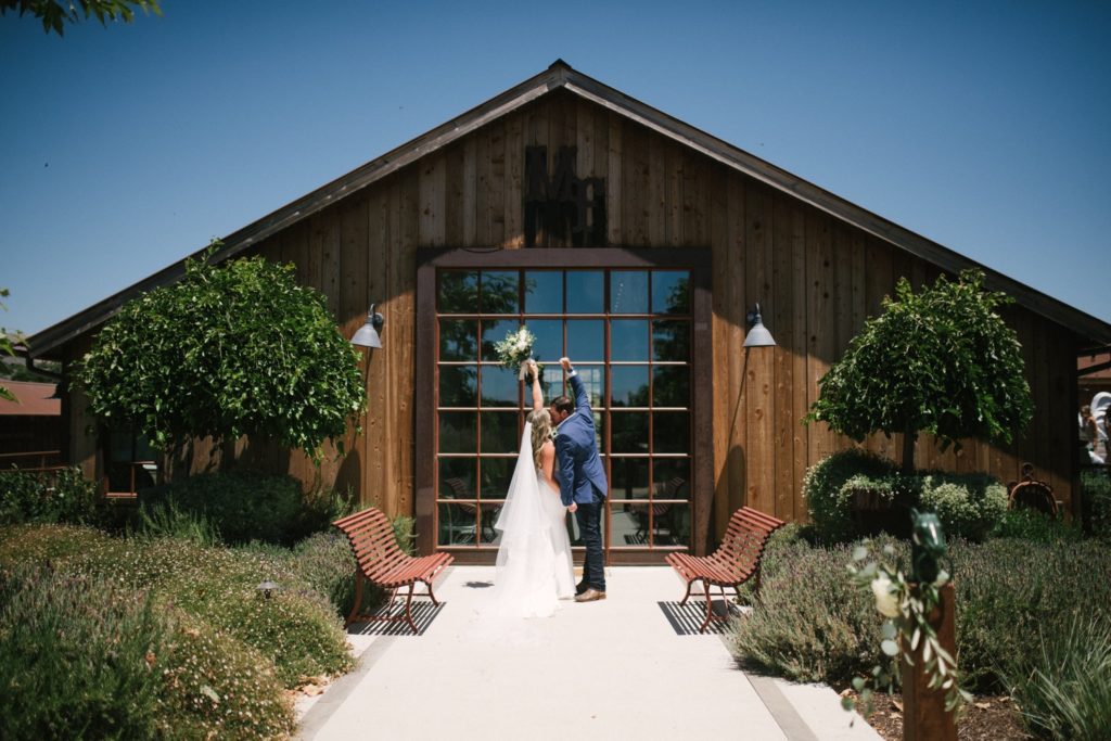 bride and groom share a kiss before getting married at marfarm. wedding photographers slo
