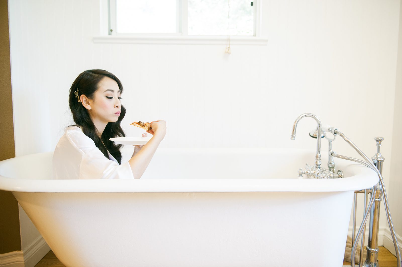 Bride sitting in tub eating pizza at Hartley Farm Wedding by Paso Robles Wedding photographer Yvonne Goll Photography