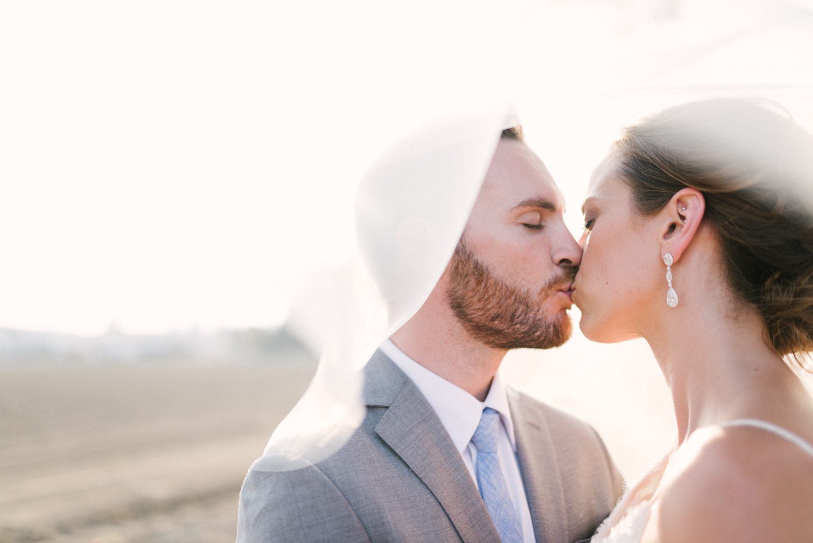 Bride and groom kissing under vail at Limoneira Ranch Wedding by California's central coast Wedding Photographer Yvonne Goll Photography