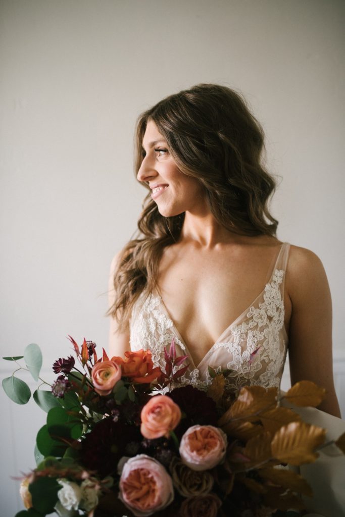 Bride with lace white dress and fall floral bouquet