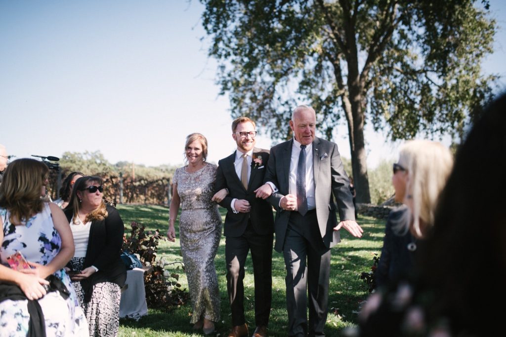 Groom walks down the aisle with both of his parents