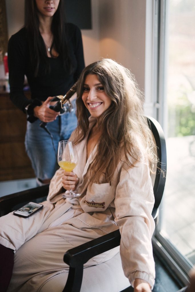 Bride getting ready for wedding while drinking wine